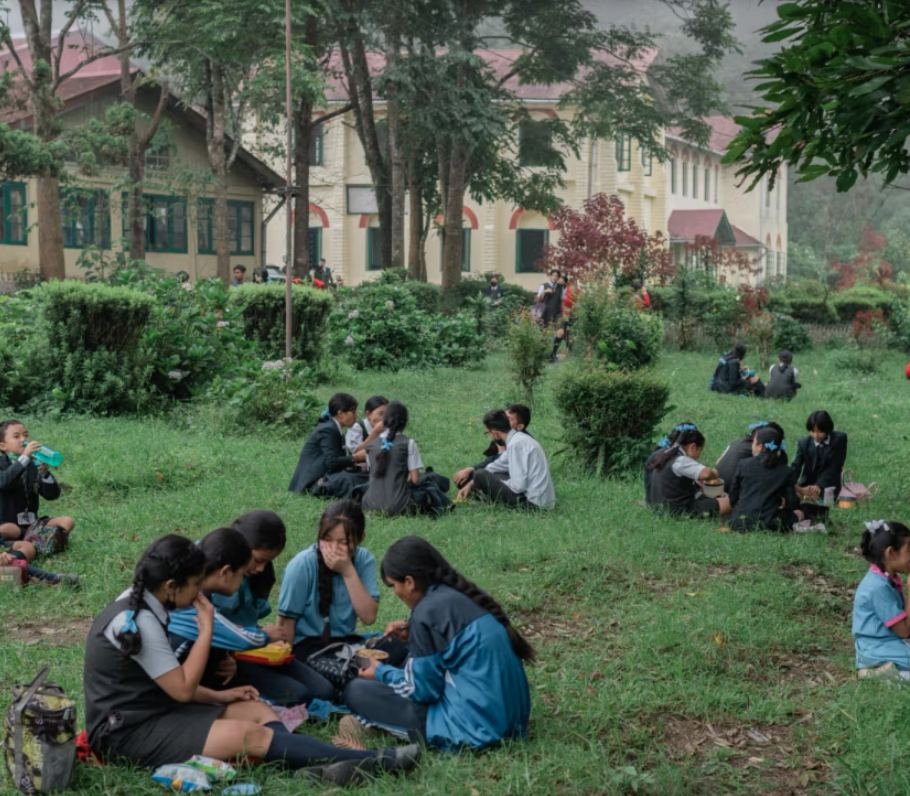Pupils of Dr Graham's Homes sitting in groups on the school lawns