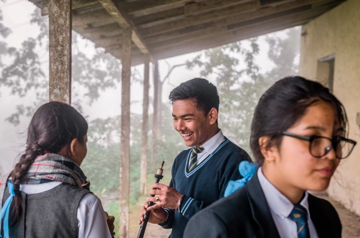 Senior pupils talking on a mist-wrapped school veranda